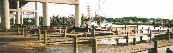 Truck Pulling Boat out of the water at the Kemah  Boat  Launching  Ramp  Under the Kemah Bridge Kemah Side , Shrimp Boats in Background