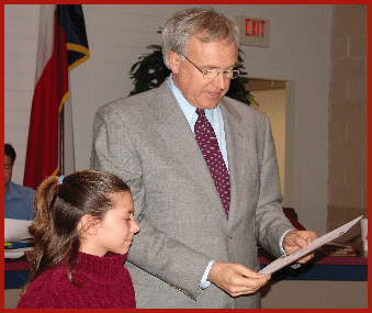 Brittan Hines, a sixth-grader from Kemah skated to
Galveston to raise money for friends father shown here with Mayor King.